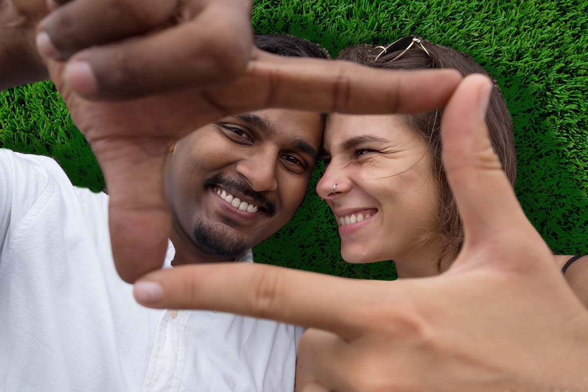 Couple lying in the grass smiling